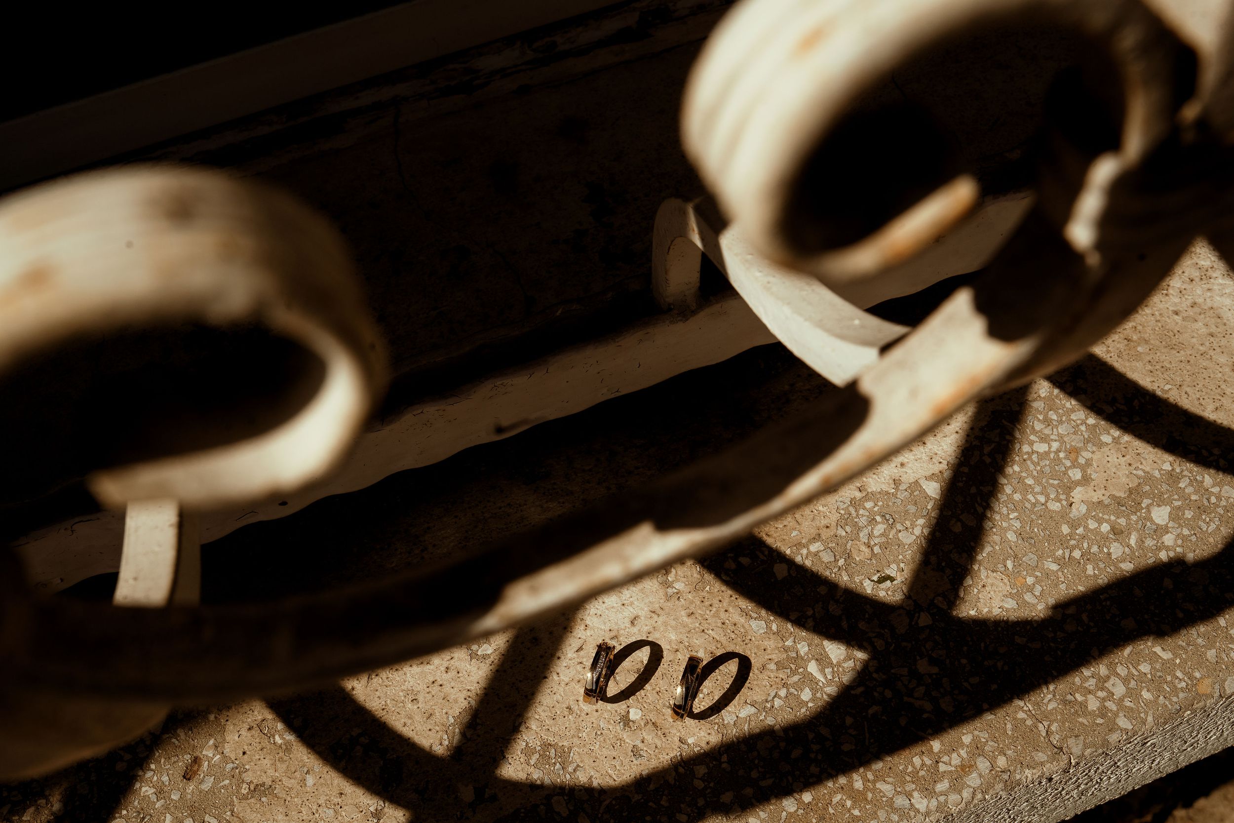 Close-up of vintage metal handcuffs casting dramatic shadows in sepia tones.