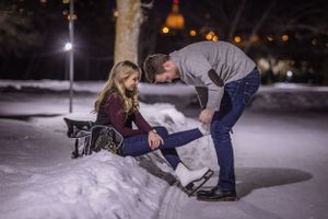 a man helping a woman put on skates
