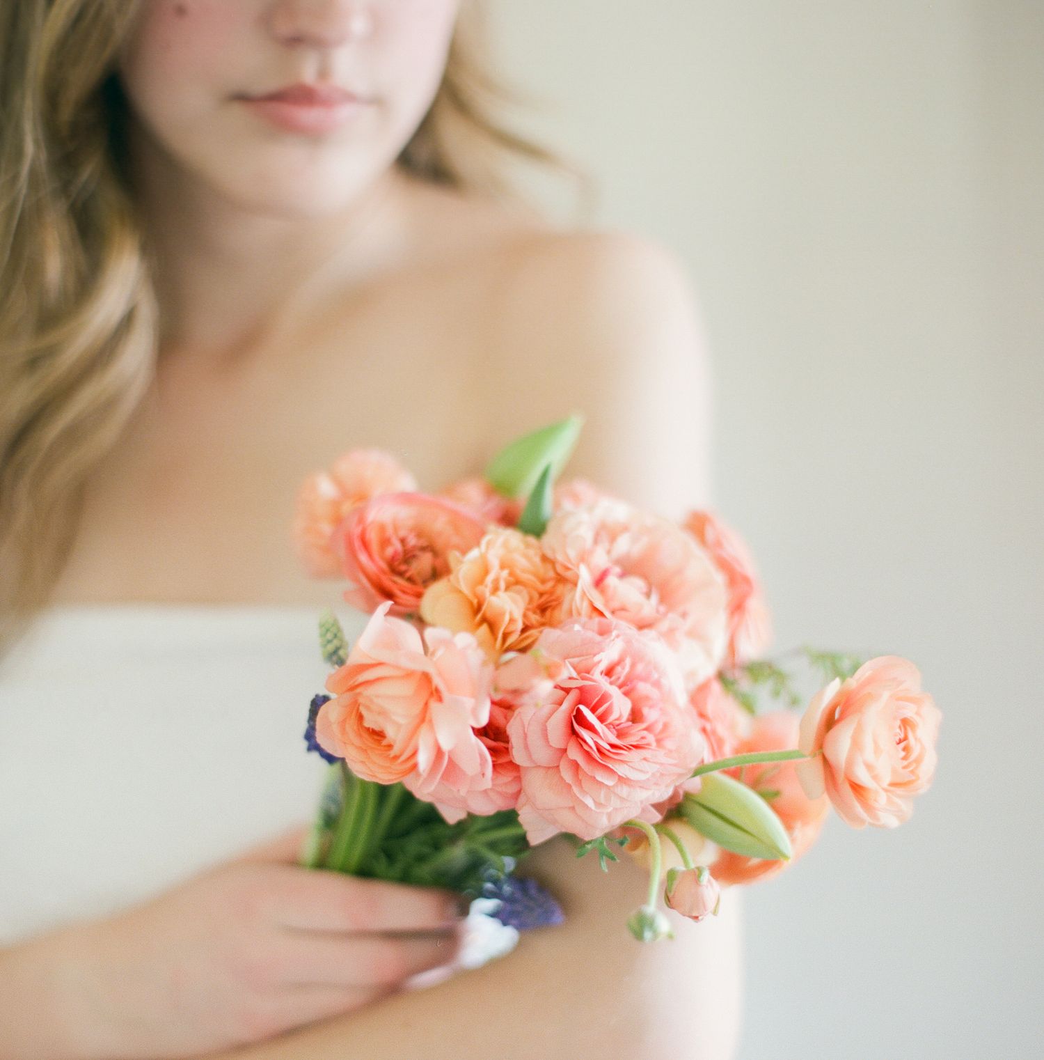 close up view of young girl from the lips to just below the shoulder in soft focus, she's holding a bouquet