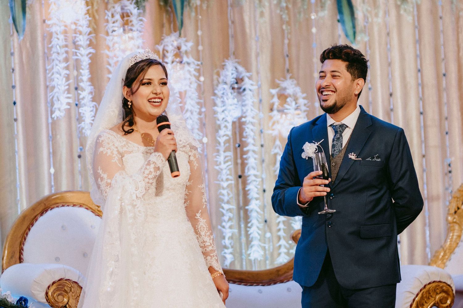 A couple laughs together during an emotional moment at their wedding celebration.