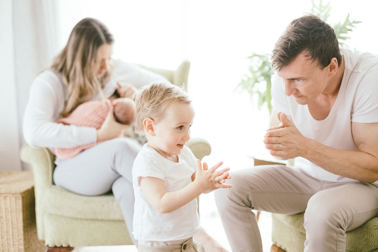 Family enjoying intimate bonding time together in a bright, airy living room setting.