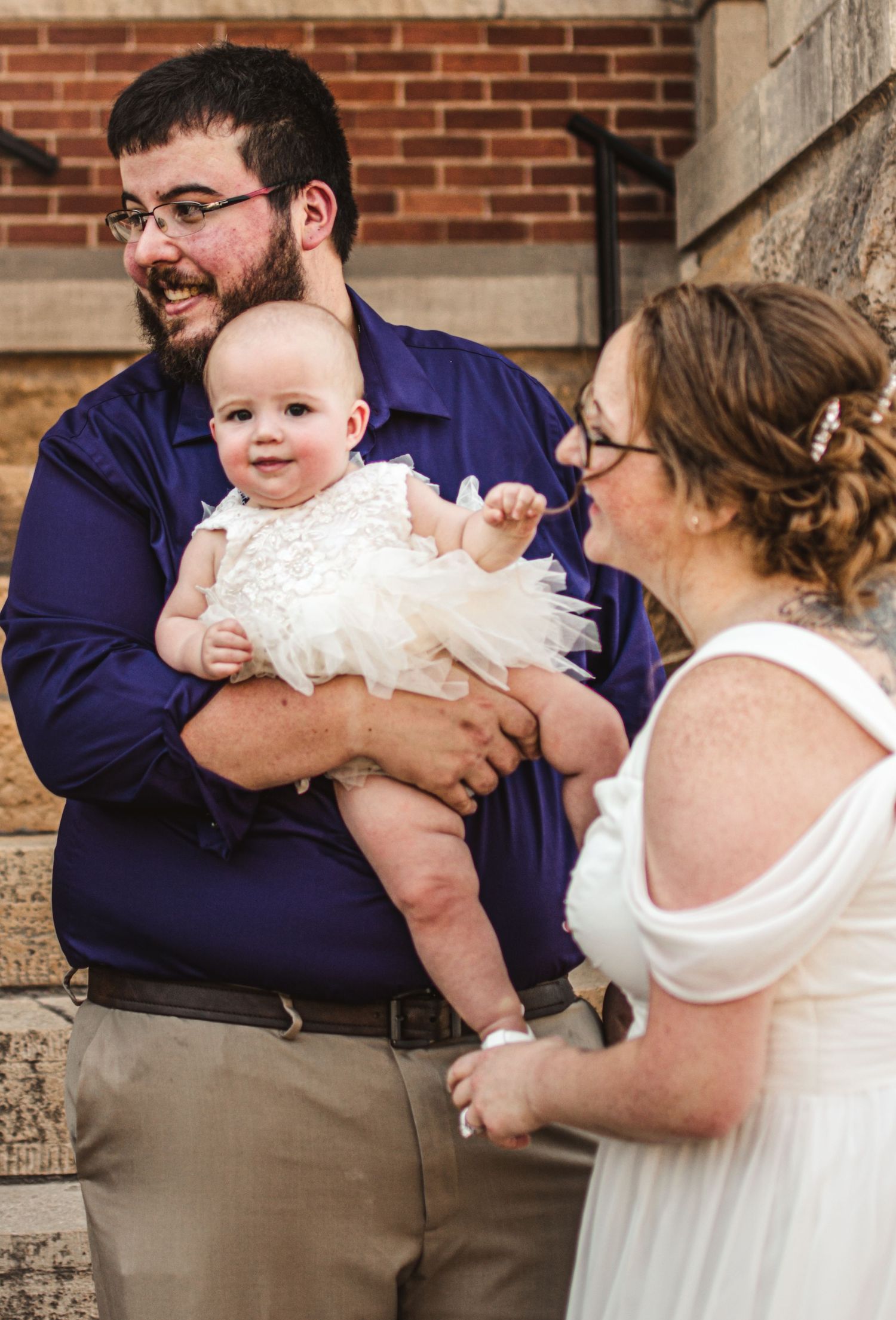 A heartwarming family moment captured outside a brick building.