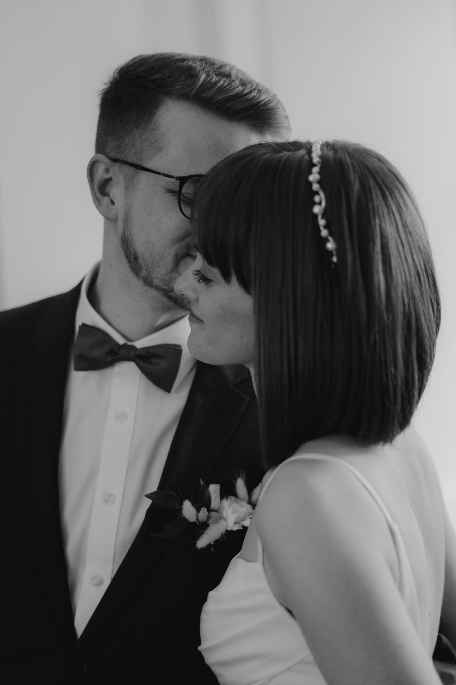 A romantic black and white portrait of a couple sharing an intimate kiss.