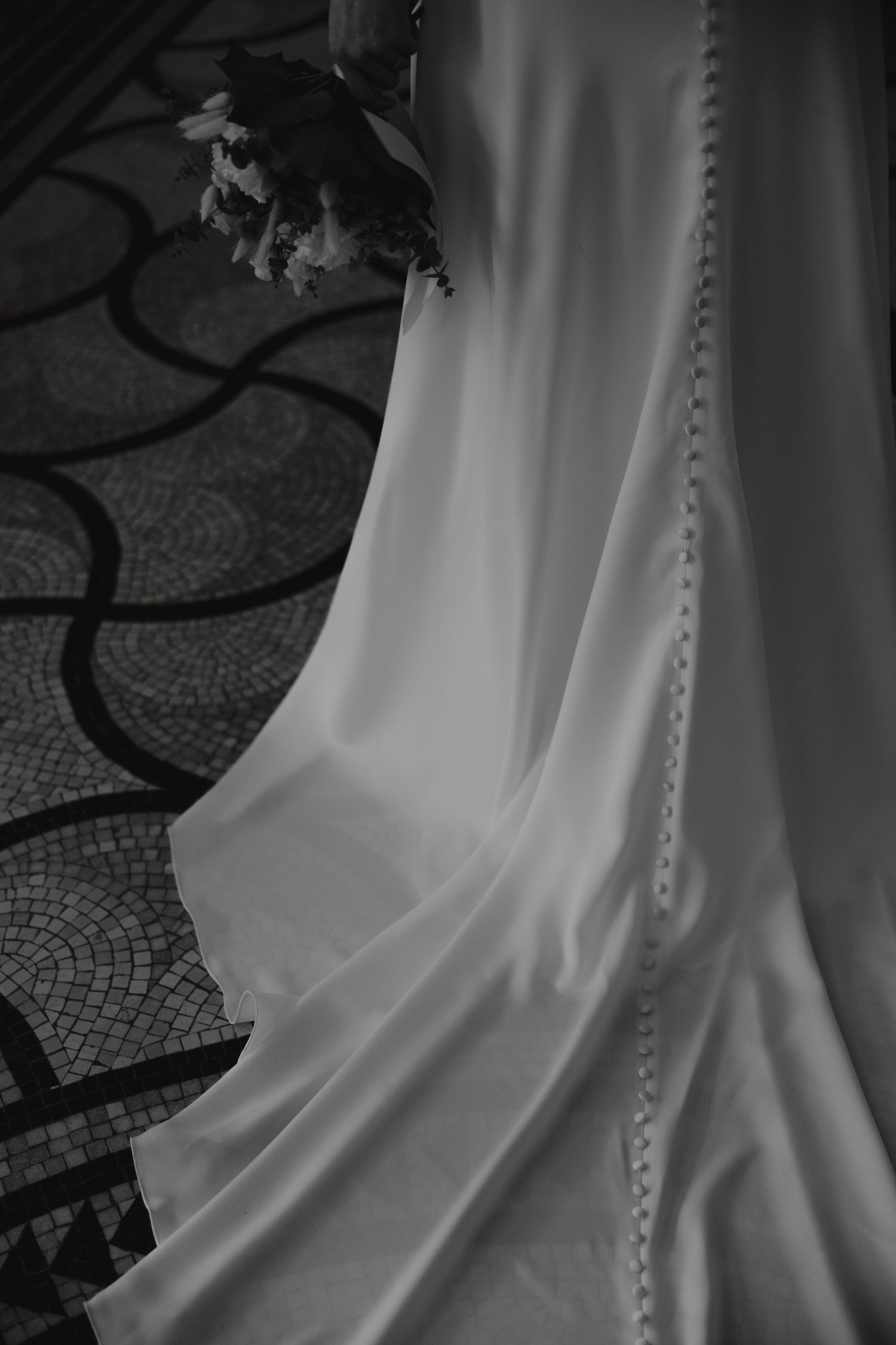 Close-up detail of a wedding dress featuring delicate button details along the back.