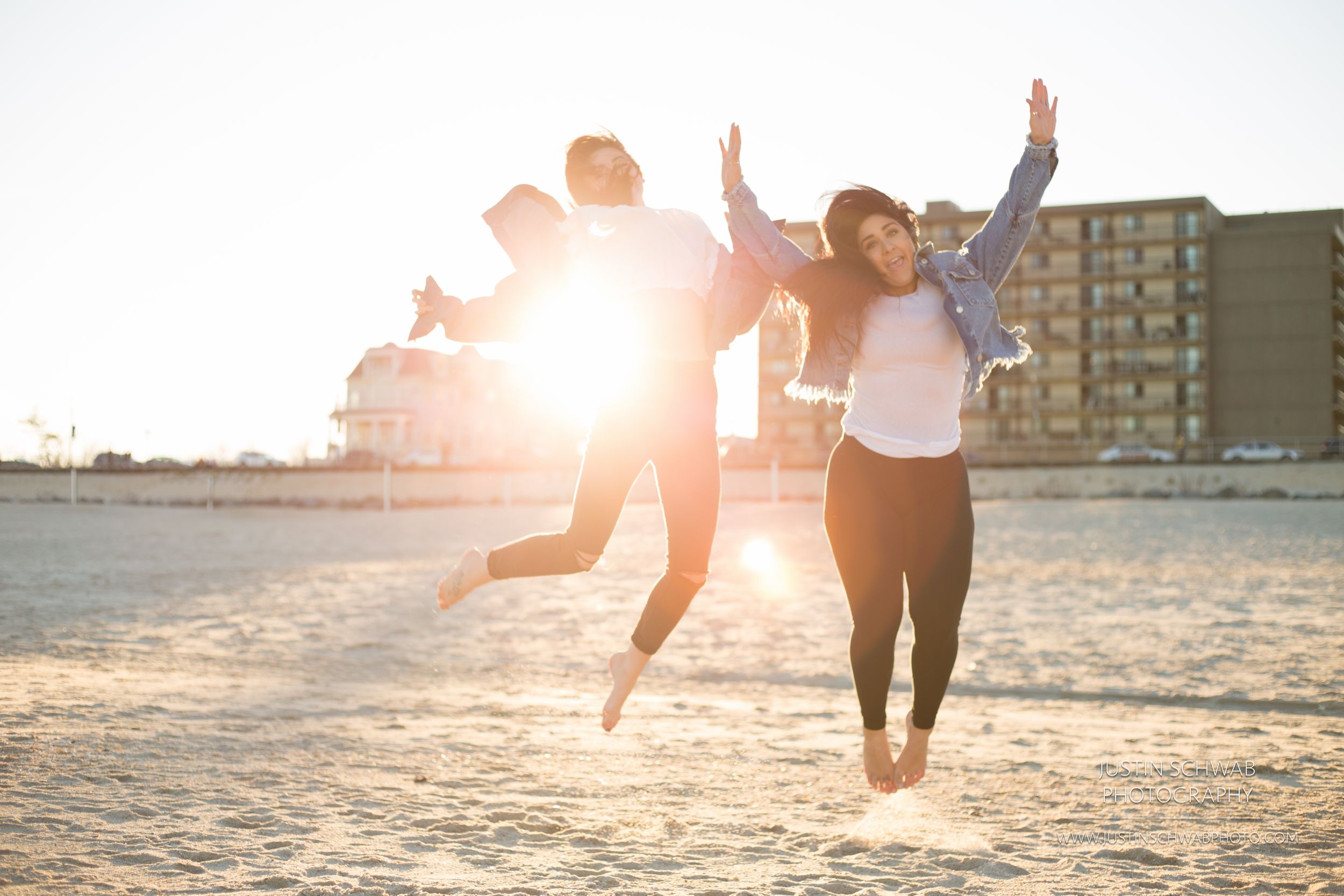 Asbury Park, New Jersey. Girls jumping on the beach. Happy.
