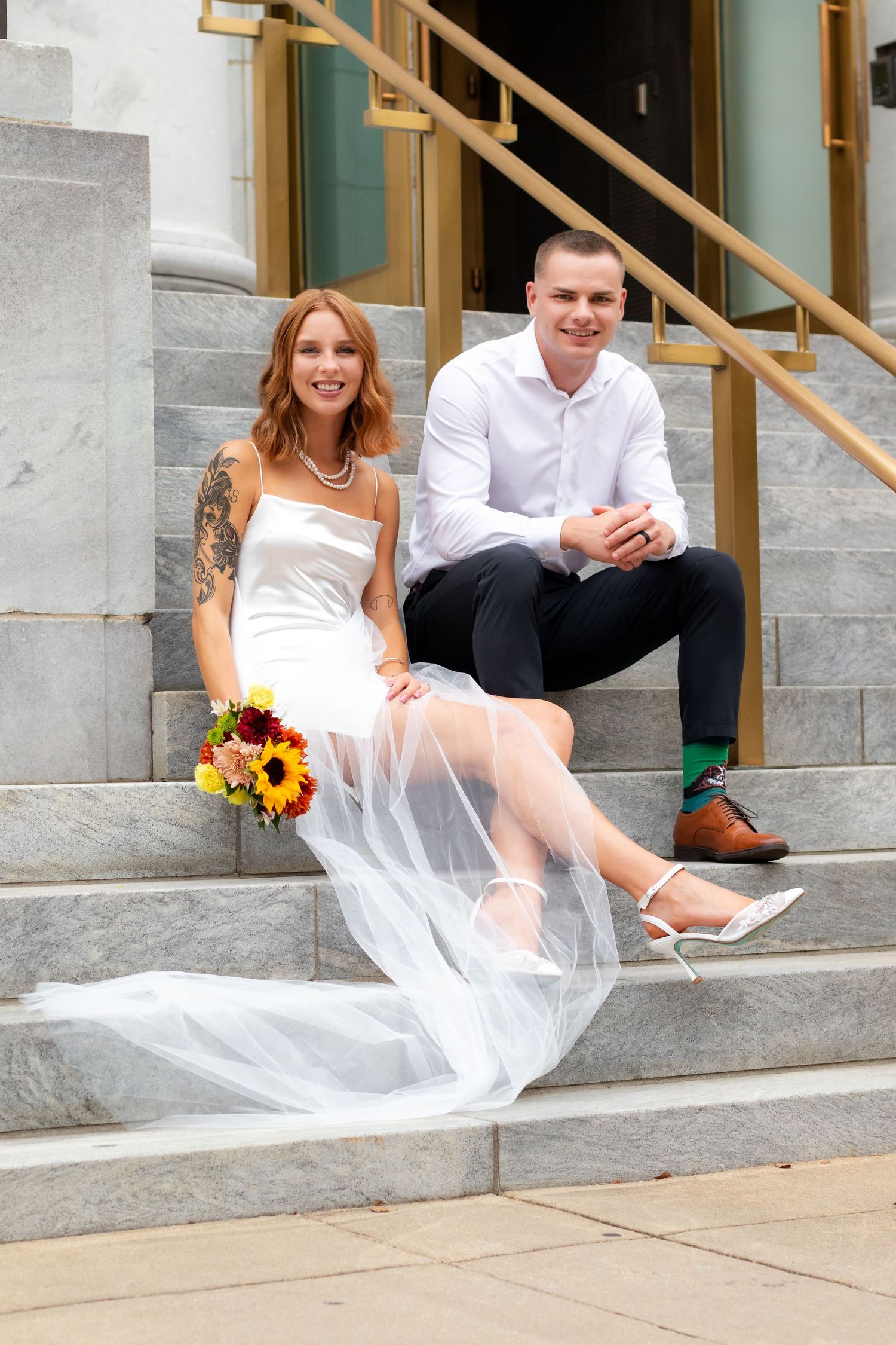 Newly weds posing for photos on the front steps of a Birmingham, AL courthouse.