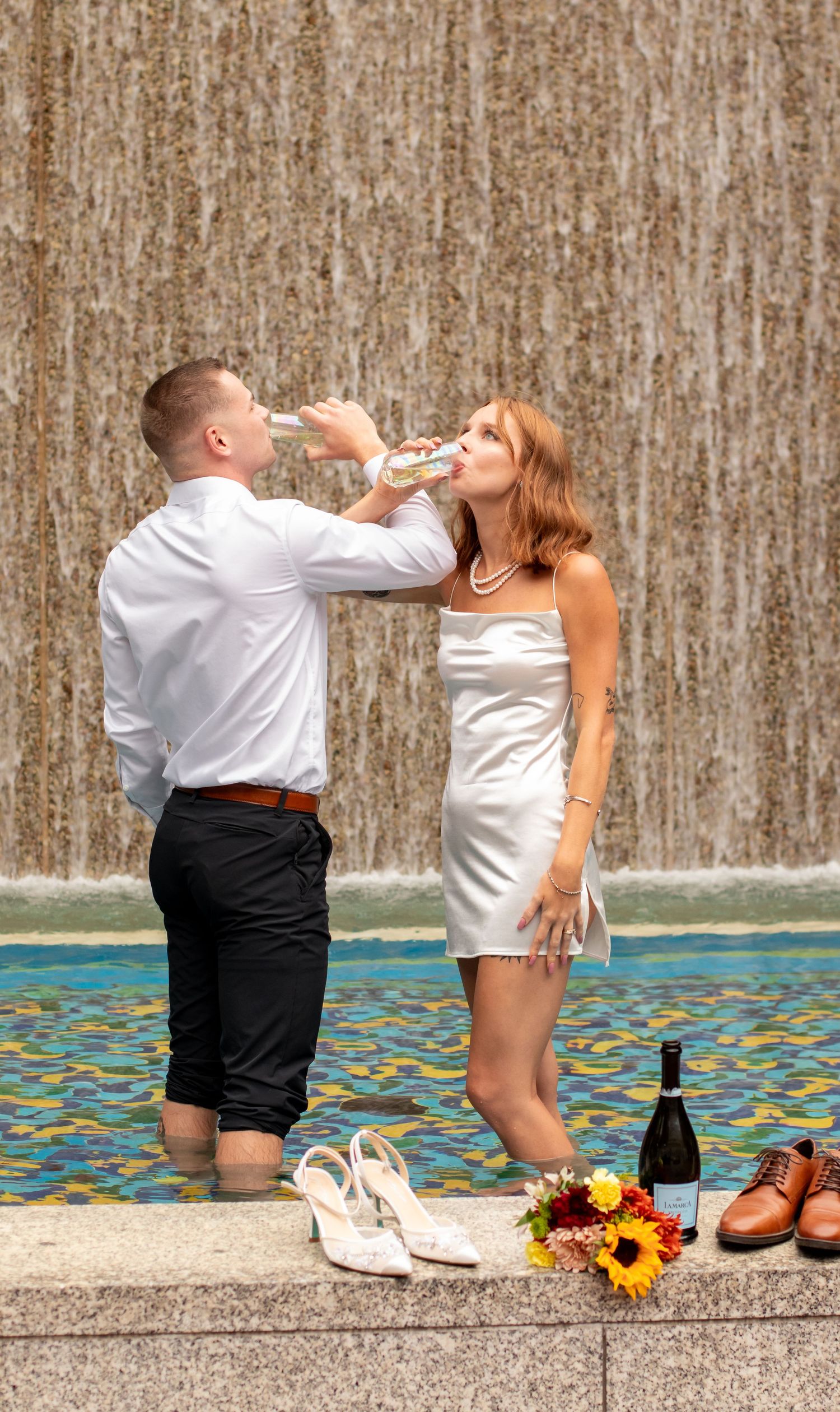 bride and groom toasting in a fountain near downtown Birmingham, AL