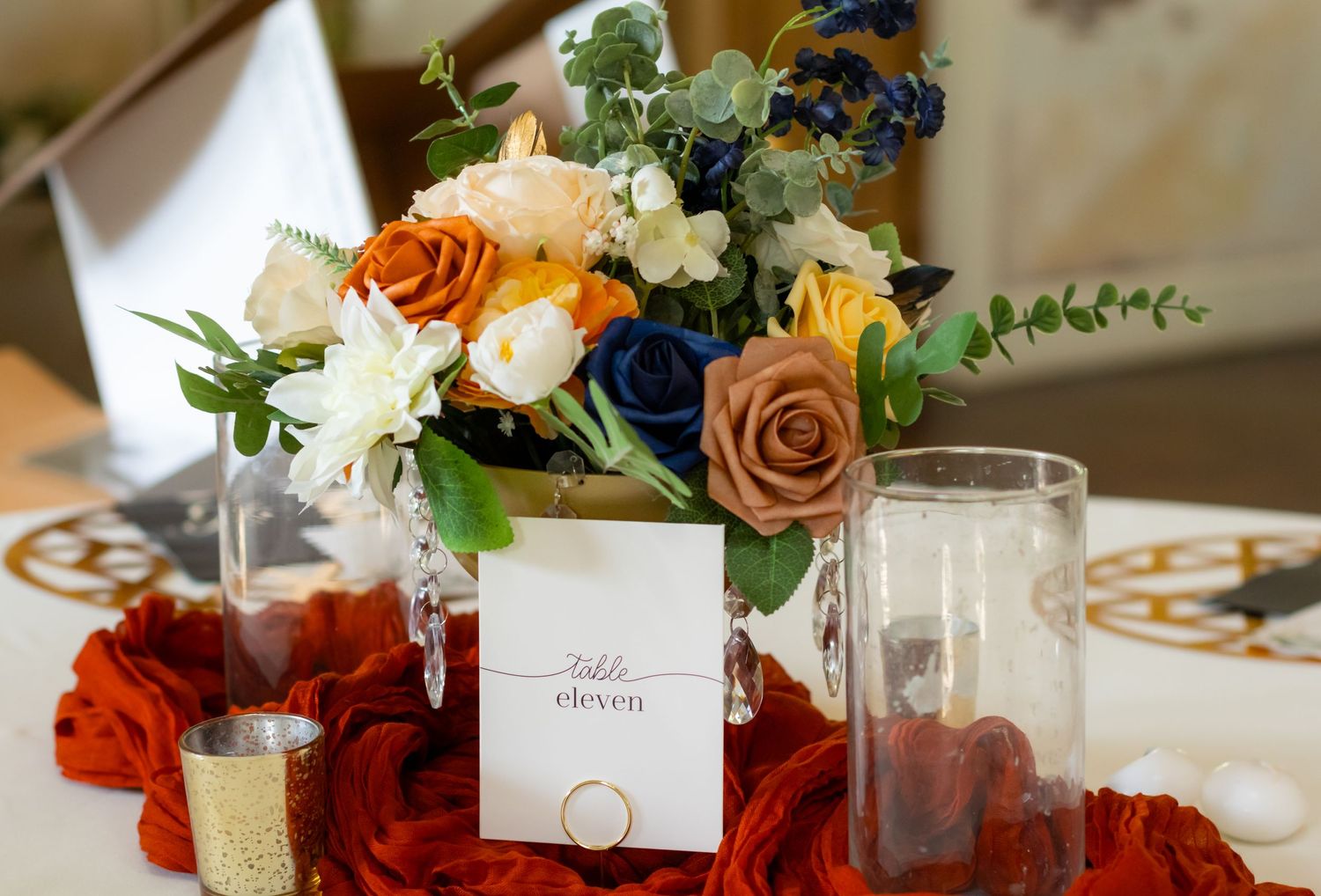 Elegant wedding table setting with floral centerpiece, place card and glassware.