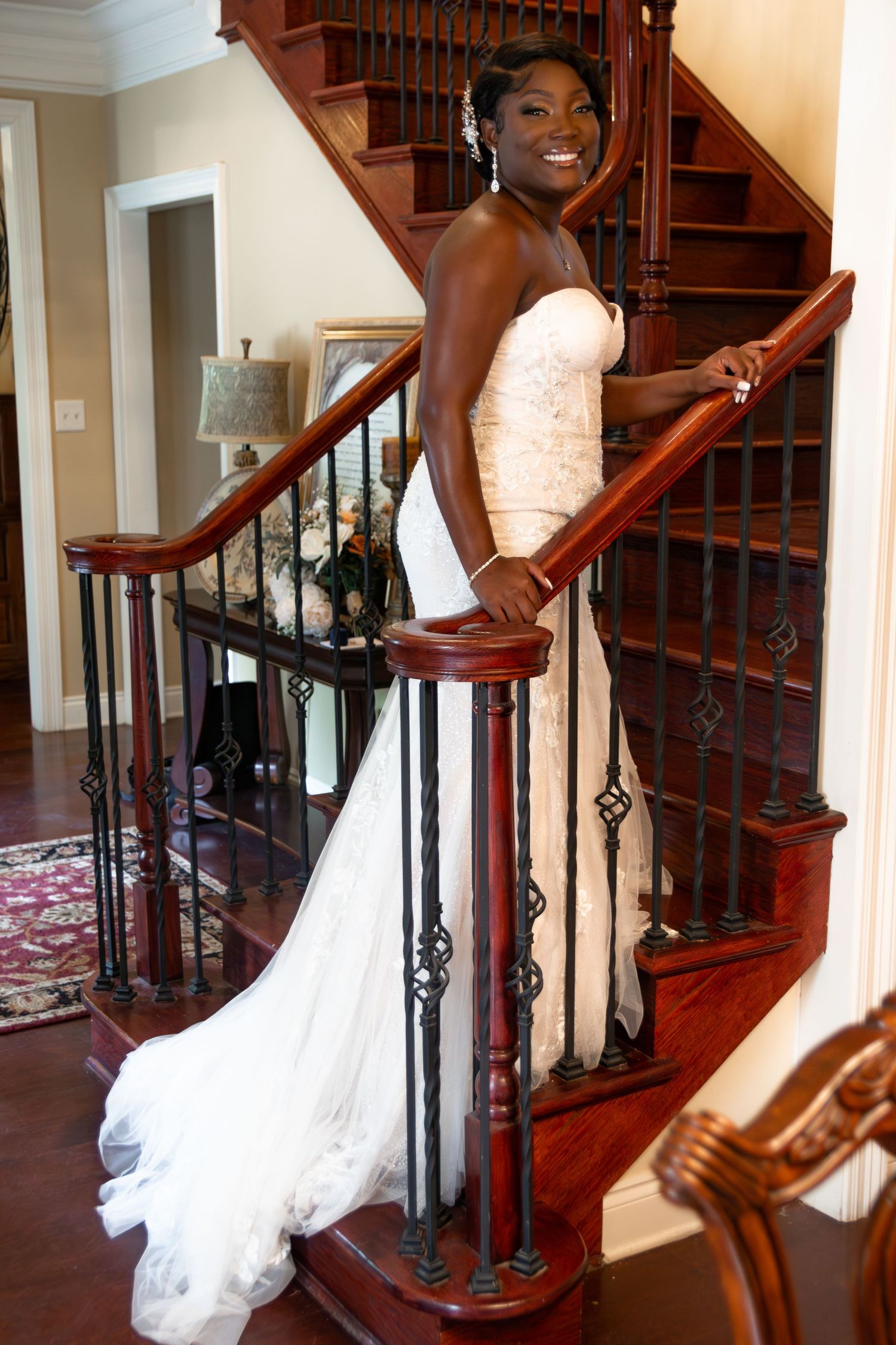 Elegant bride standing at the bottom of a stairwell before her wedding ceremony in Loxley, AL.