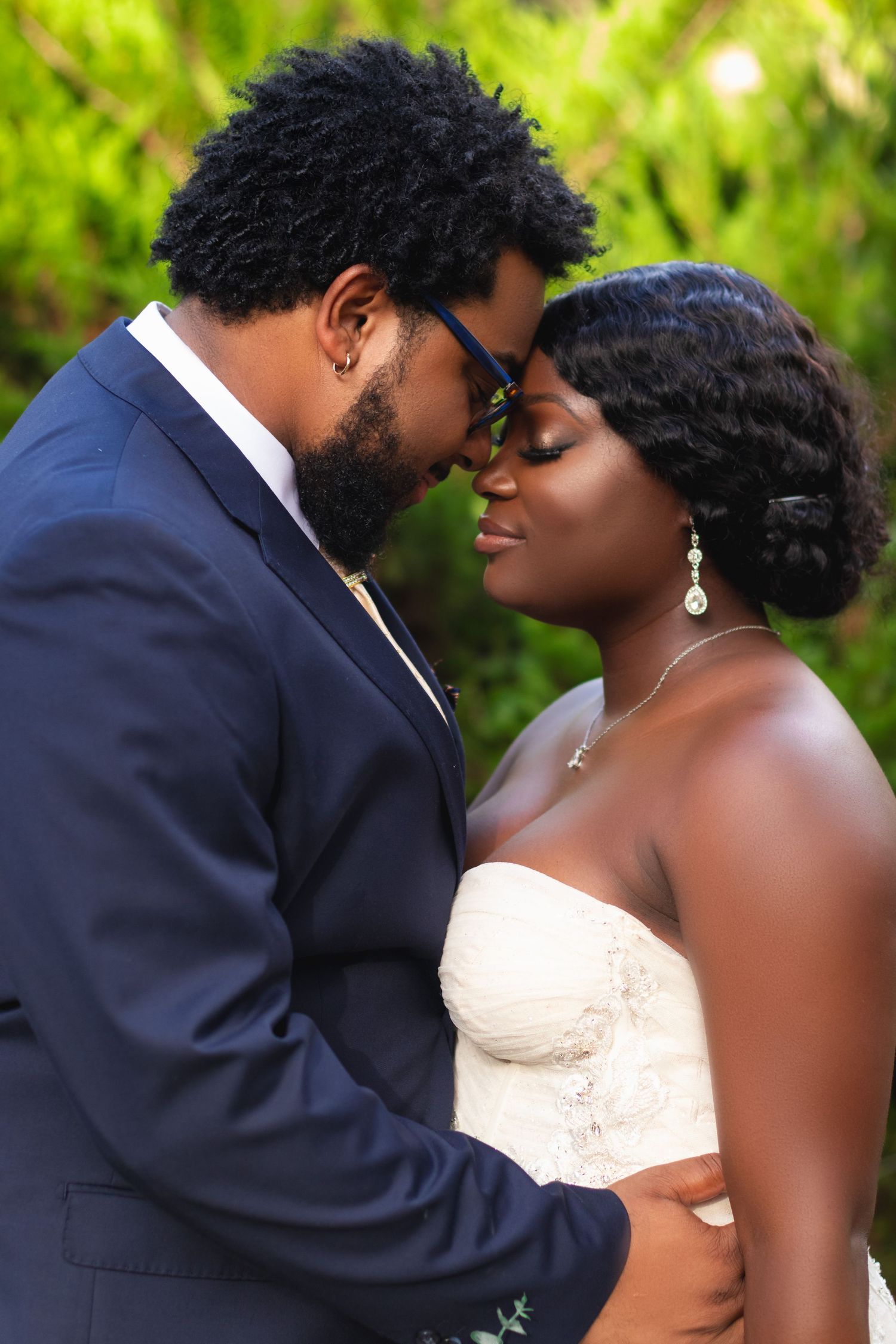 Intimate romantic moment between newlyweds with the bride in a strapless gown and groom in navy suit.