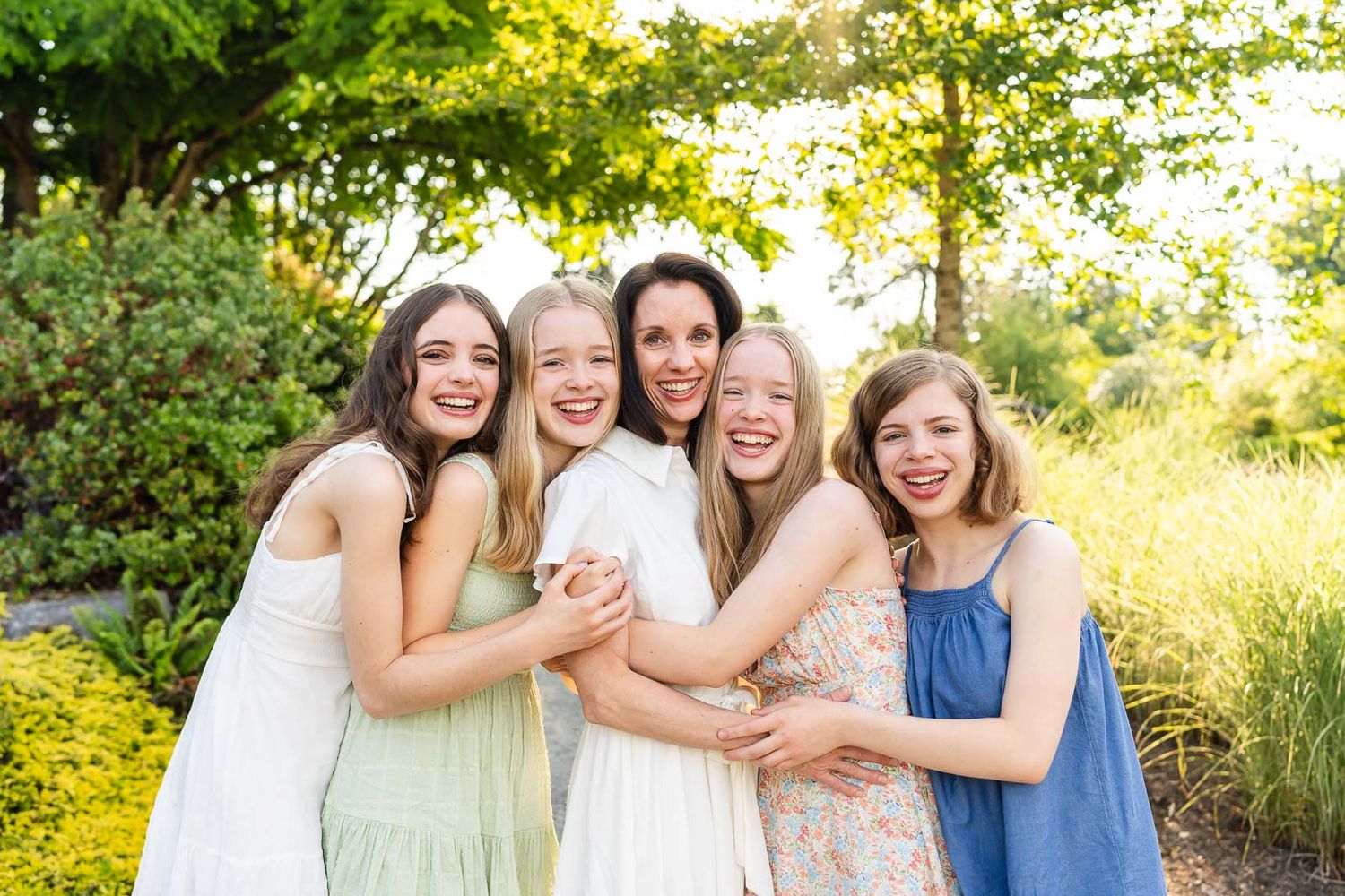 Mother and teenage daughters smile for posed portrait.
