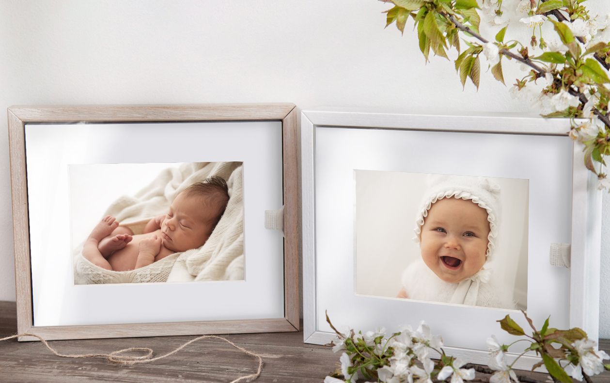 Two photo display boxes on a shelf, showing a newborn baby and a 7 month baby.