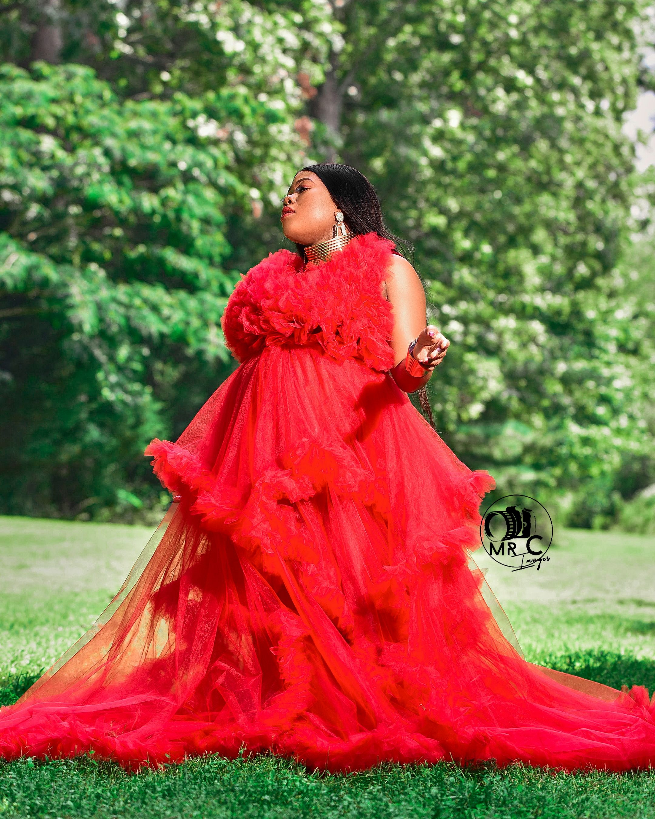 A flowing red tulle gown with ruffled details captured in a dreamy outdoor photoshoot.