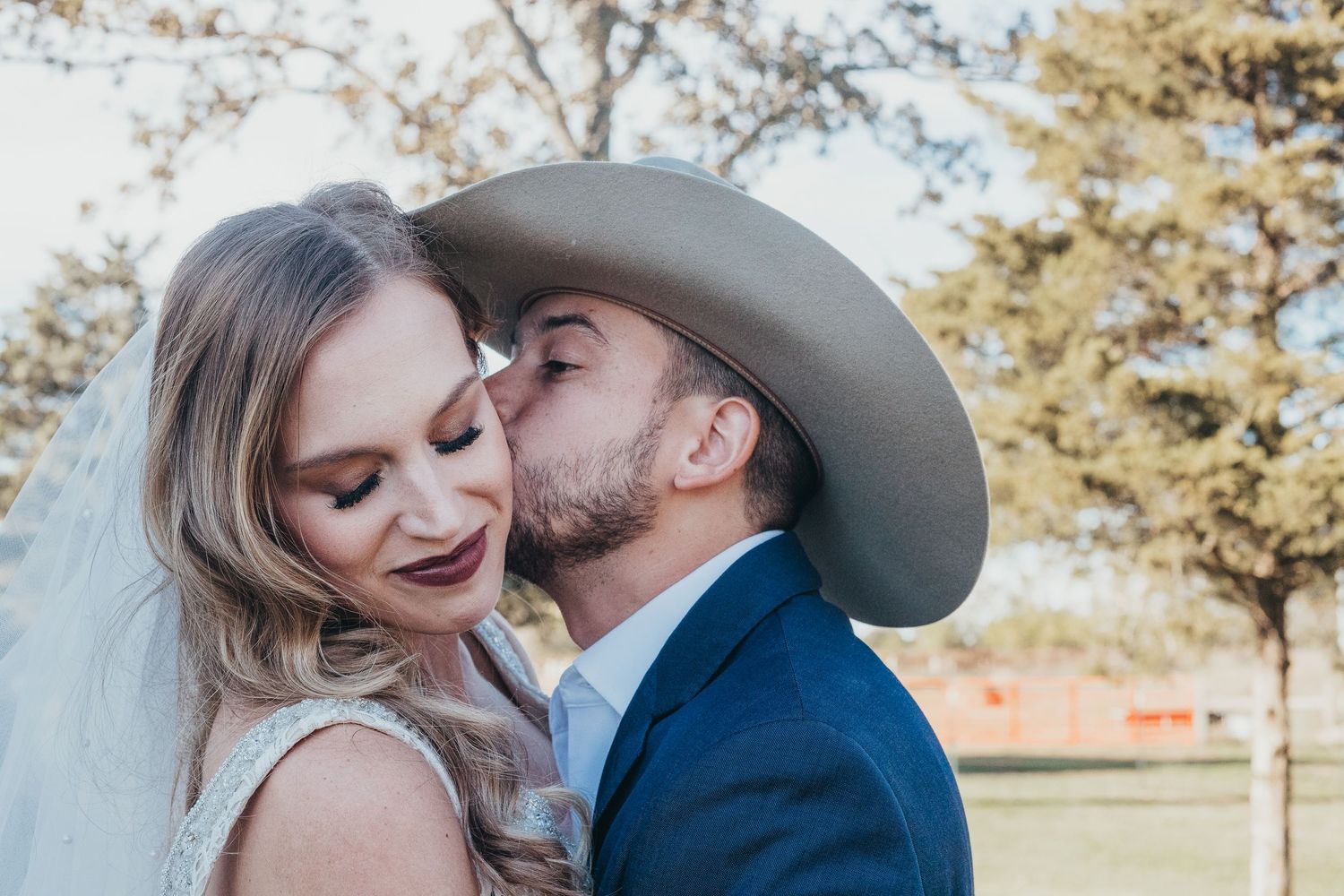 A romantic outdoor portrait of a couple sharing an intimate moment in natural lighting.