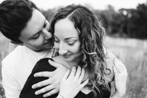 Black and white portrait of couple embracing tenderly in outdoor setting.
