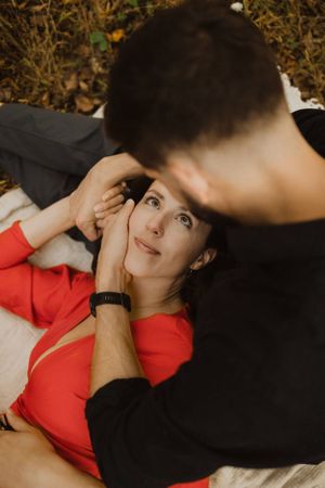 Intimate portrait of couple lying on blanket during autumn outdoor photoshoot.