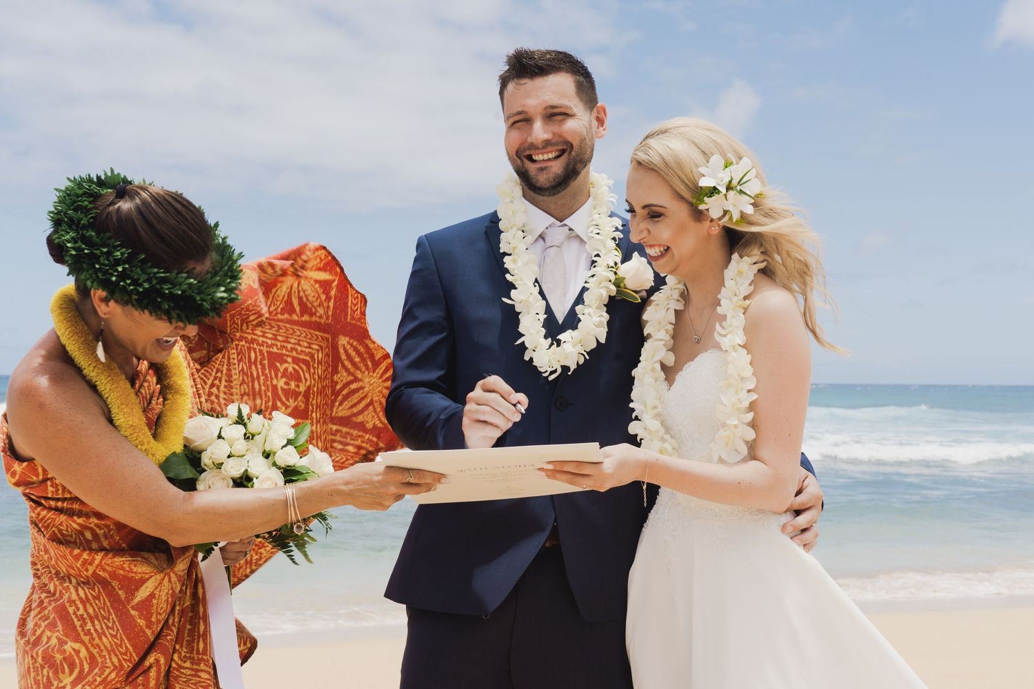 Wedding ceremony on a Hawaiian beach with traditional lei exchange.