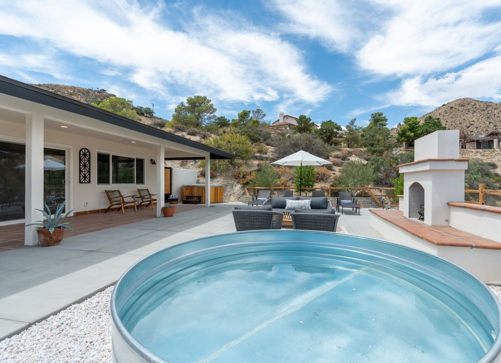 Infinity pool overlooking desert mountains with lounge chairs and landscaping.