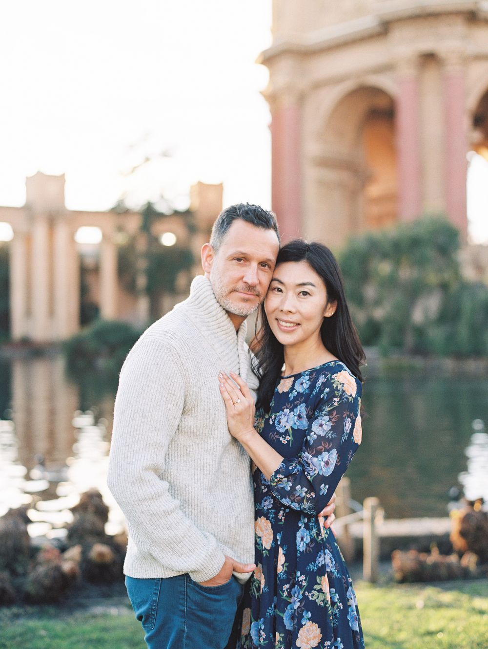A couple posing together at the Palace of Fine Arts with reflection pool at sunset.