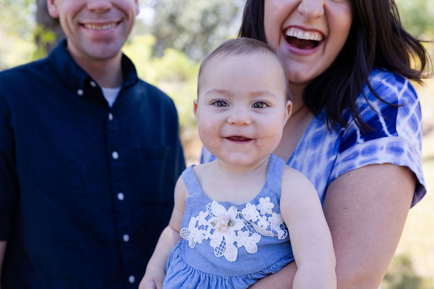 one year old portraits with mom and dad in the background in Folsom, California