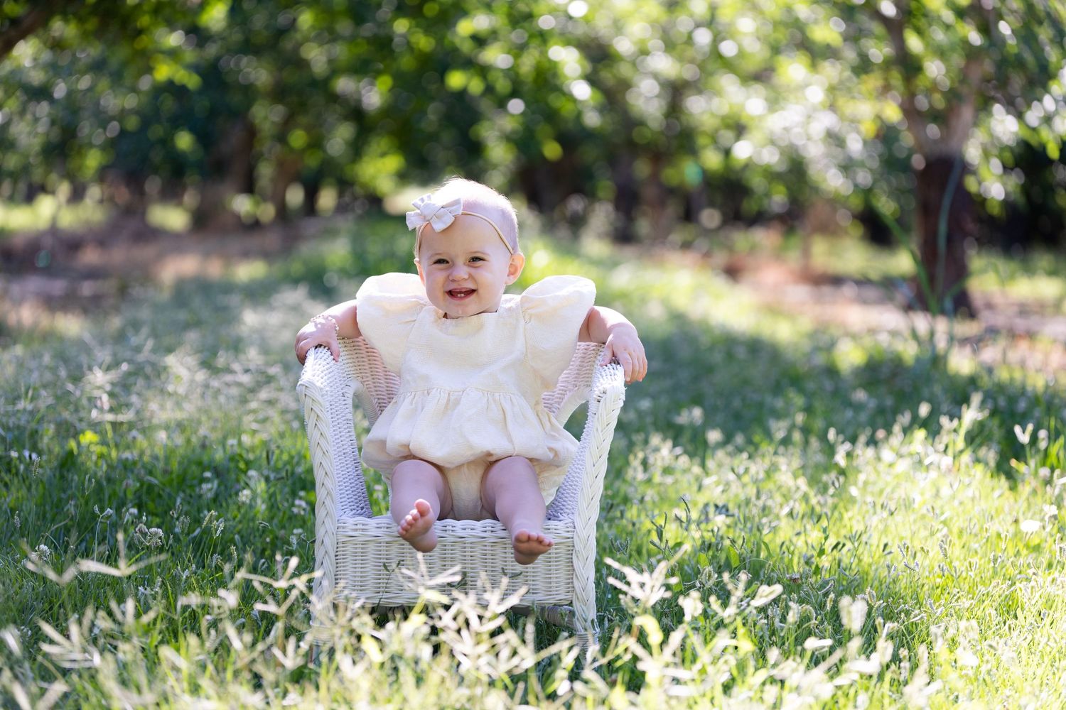 One Year Old Portraits in Walnut Orchard with white wicker chair in Orland, California