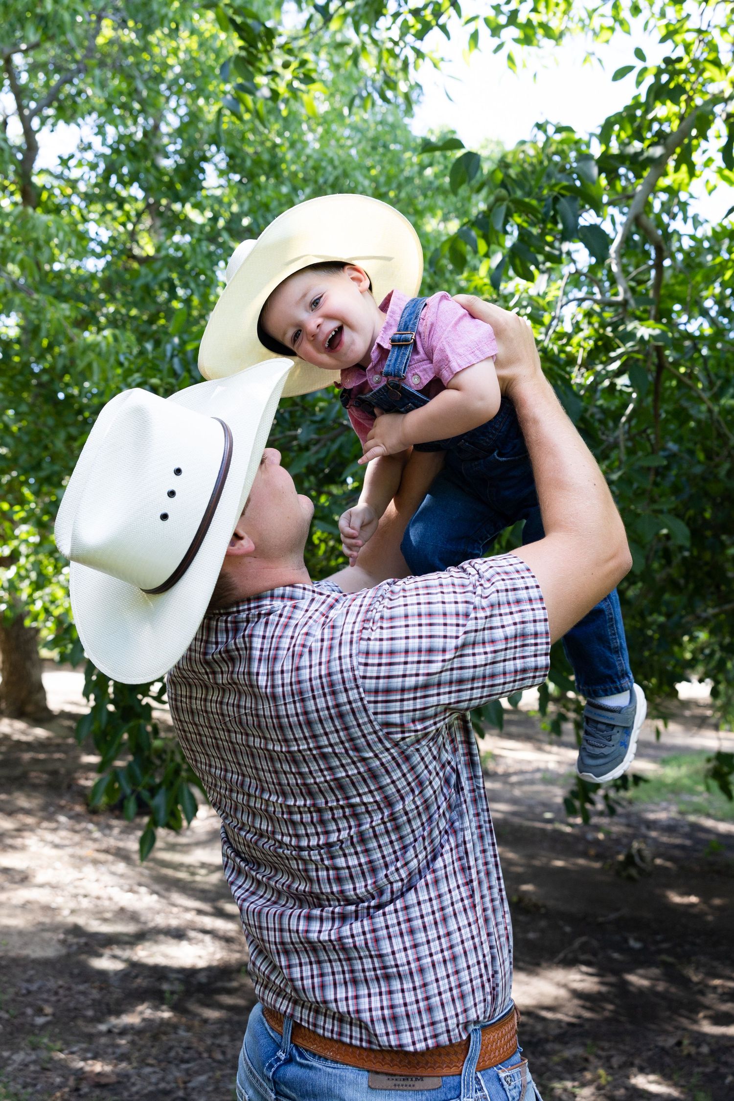dad and son wearing cowboy hats in orland, california orchard