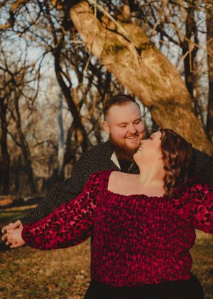 Romantic couple sharing tender moment in autumn park with golden sunlight.