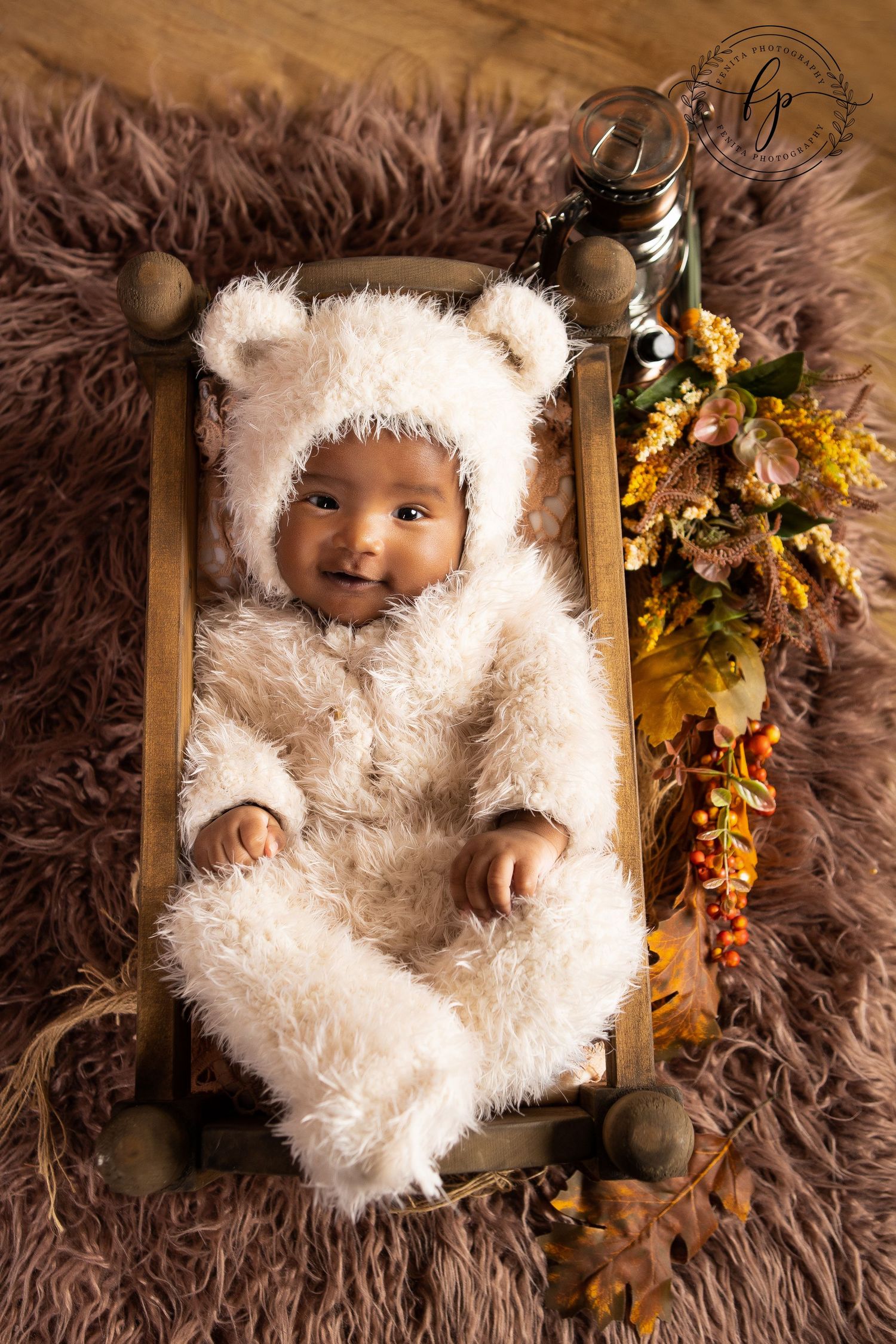 baby girl in a teddy bear costume smiling to the camera