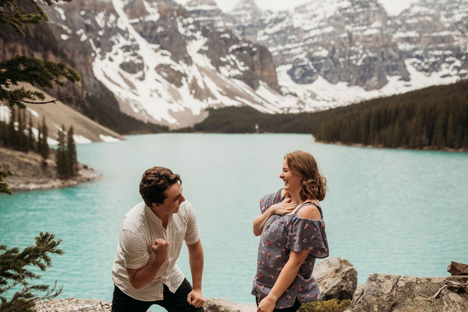 A candid moment of laughter by the stunning turquoise waters of Moraine Lake.