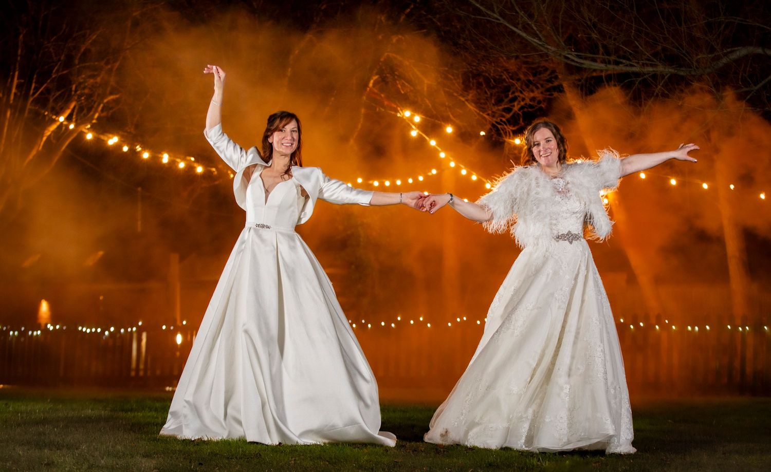 Wedding celebration at night with string lights creating a magical outdoor atmosphere.