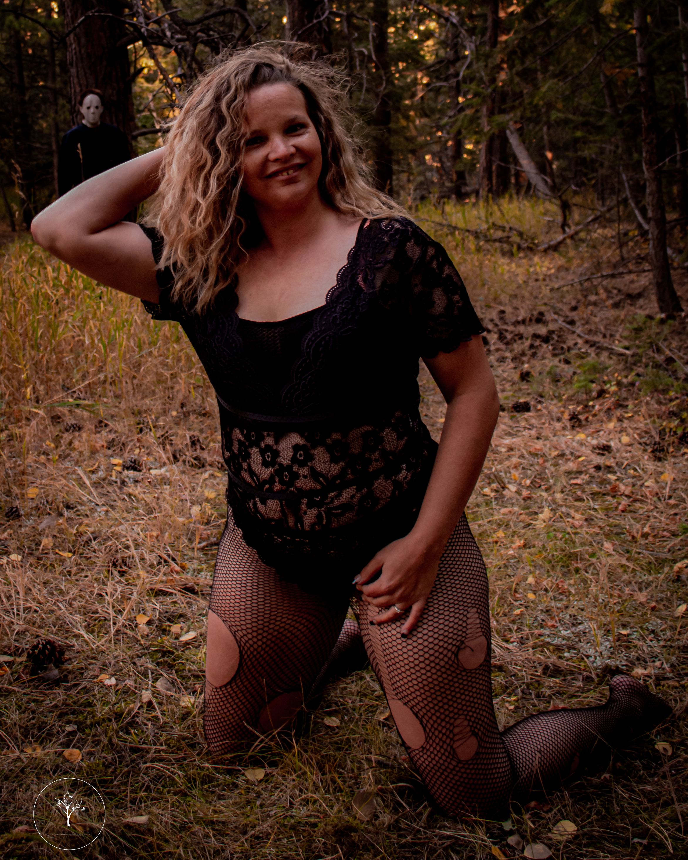 Artistic autumn photoshoot in a wooded setting with fallen leaves.