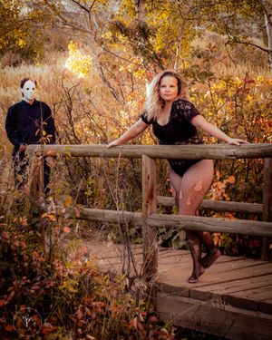 Artistic autumn photoshoot on wooden bridge with golden foliage.