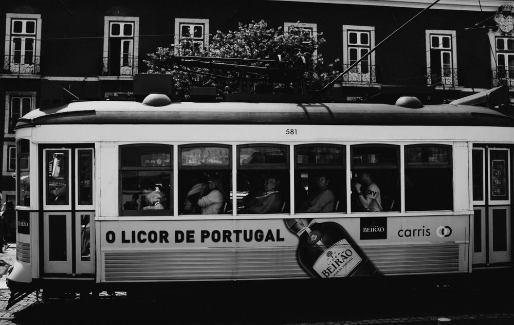 Black and white urban scene with tram and street signs in silhouette.