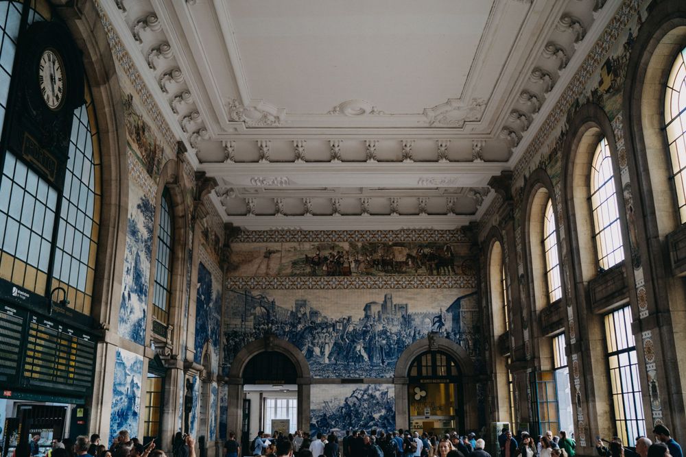 Ornate interior hall with blue and white tiled walls and decorative ceiling details.