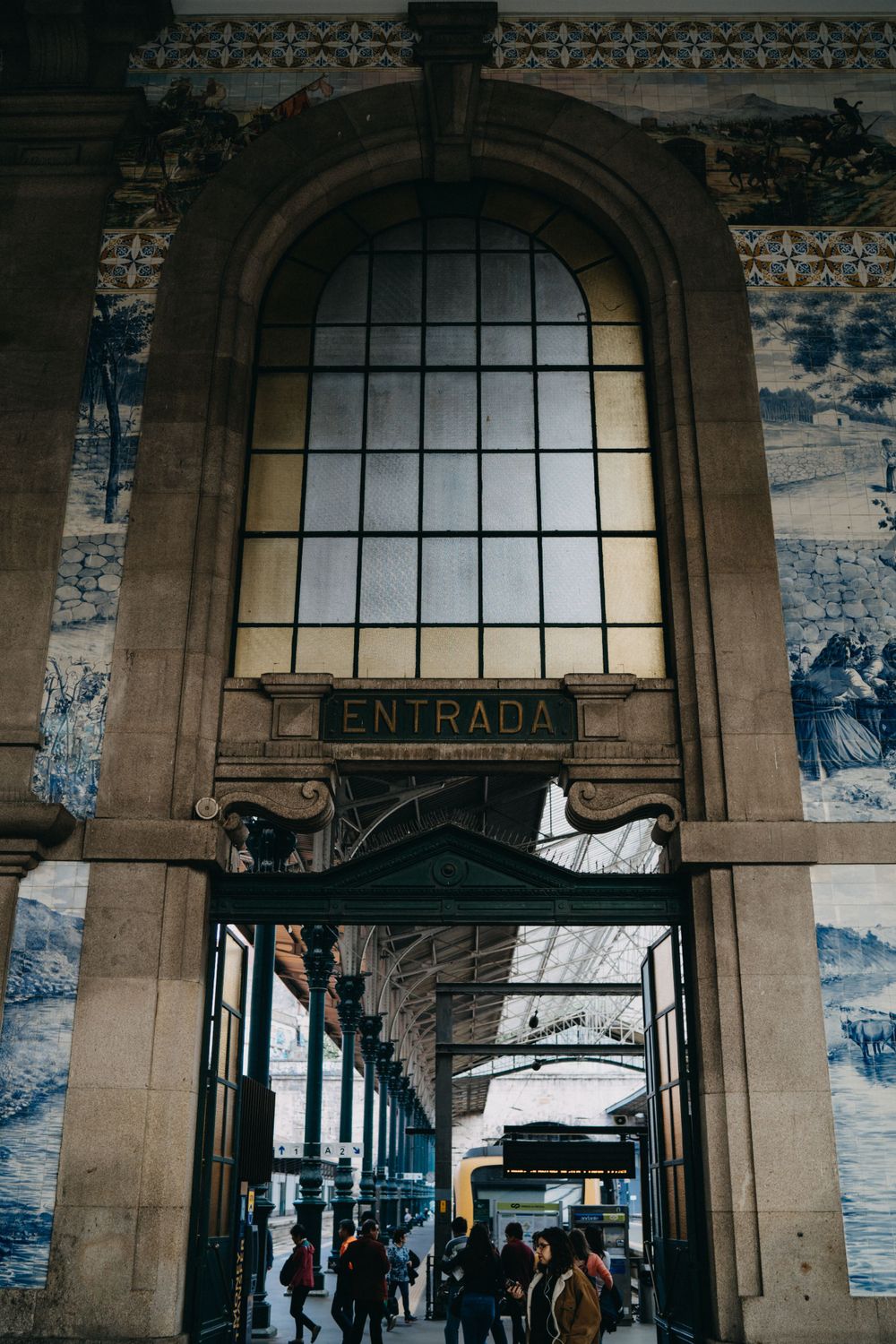 Historic train station entrance with arched windows and traditional blue tile work.