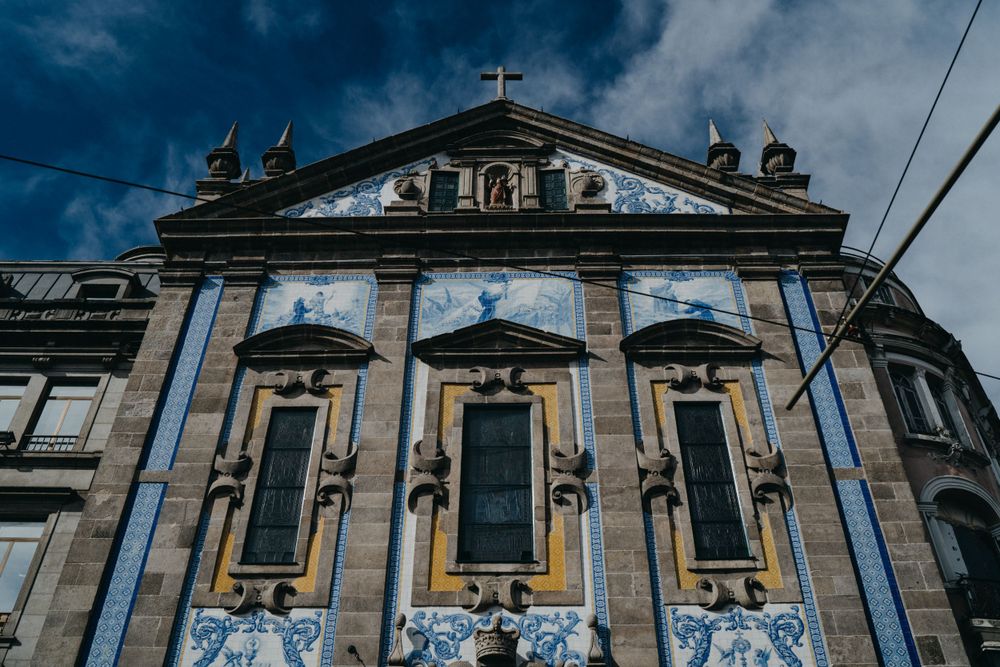 Classical church facade with ornate architectural details against deep blue sky.