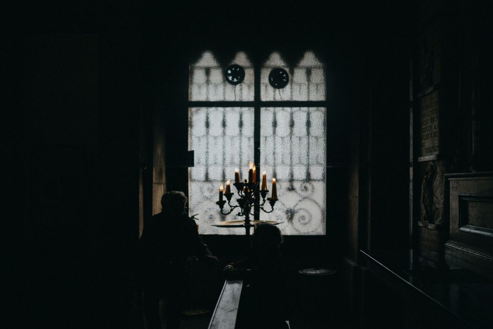 Dark interior space with bright windows casting dramatic shadows.