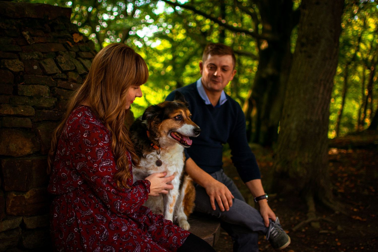 Mum and dad with their furry baby in the woods