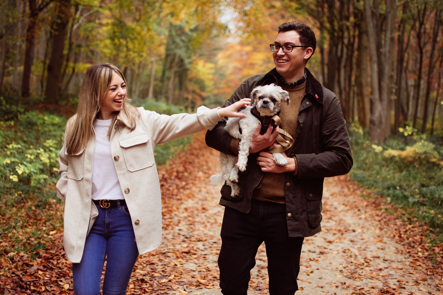 mum and dad with their fur Baby walking in the woods at autumn