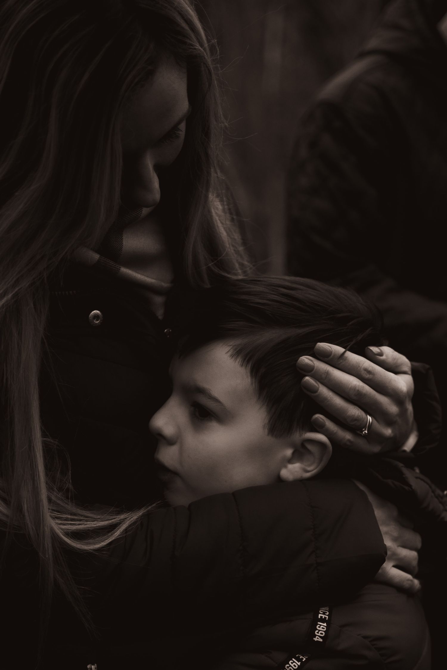 Mum holding her young son, stroking his hair