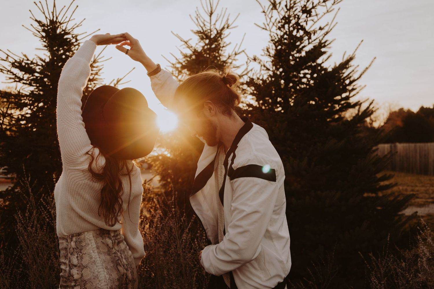 Image of woman and man dancing in front of sunset.