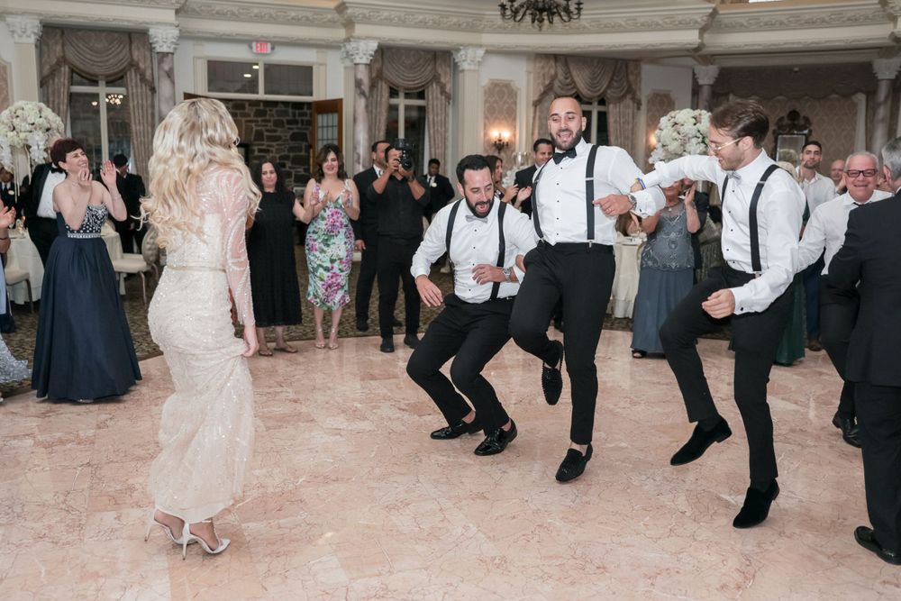 Wedding guests performing synchronized dance moves in an elegant reception venue.