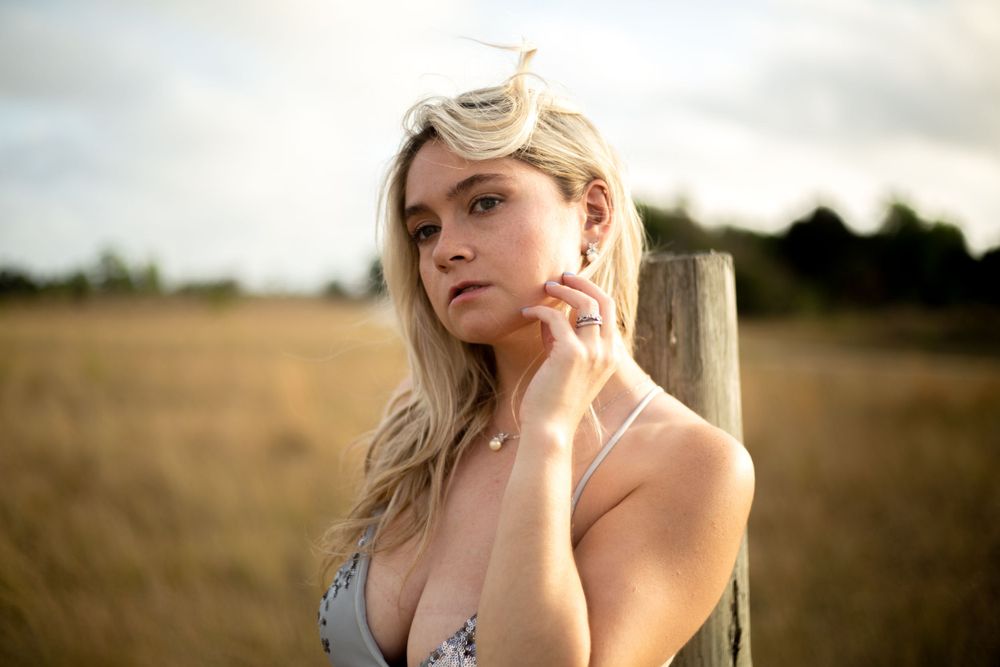 A dreamy golden hour portrait in a field with soft lighting and natural scenery.
