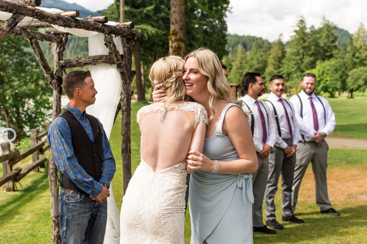 Bride hugging sister in law during wedding ceremony. Photo taken at Hope Golf Course by Kari Mills Photography.