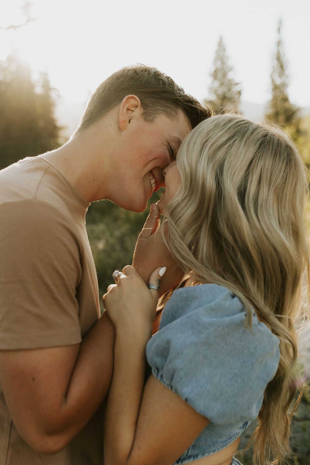 Intimate close-up of couple sharing joyful moment in outdoor mountain setting.