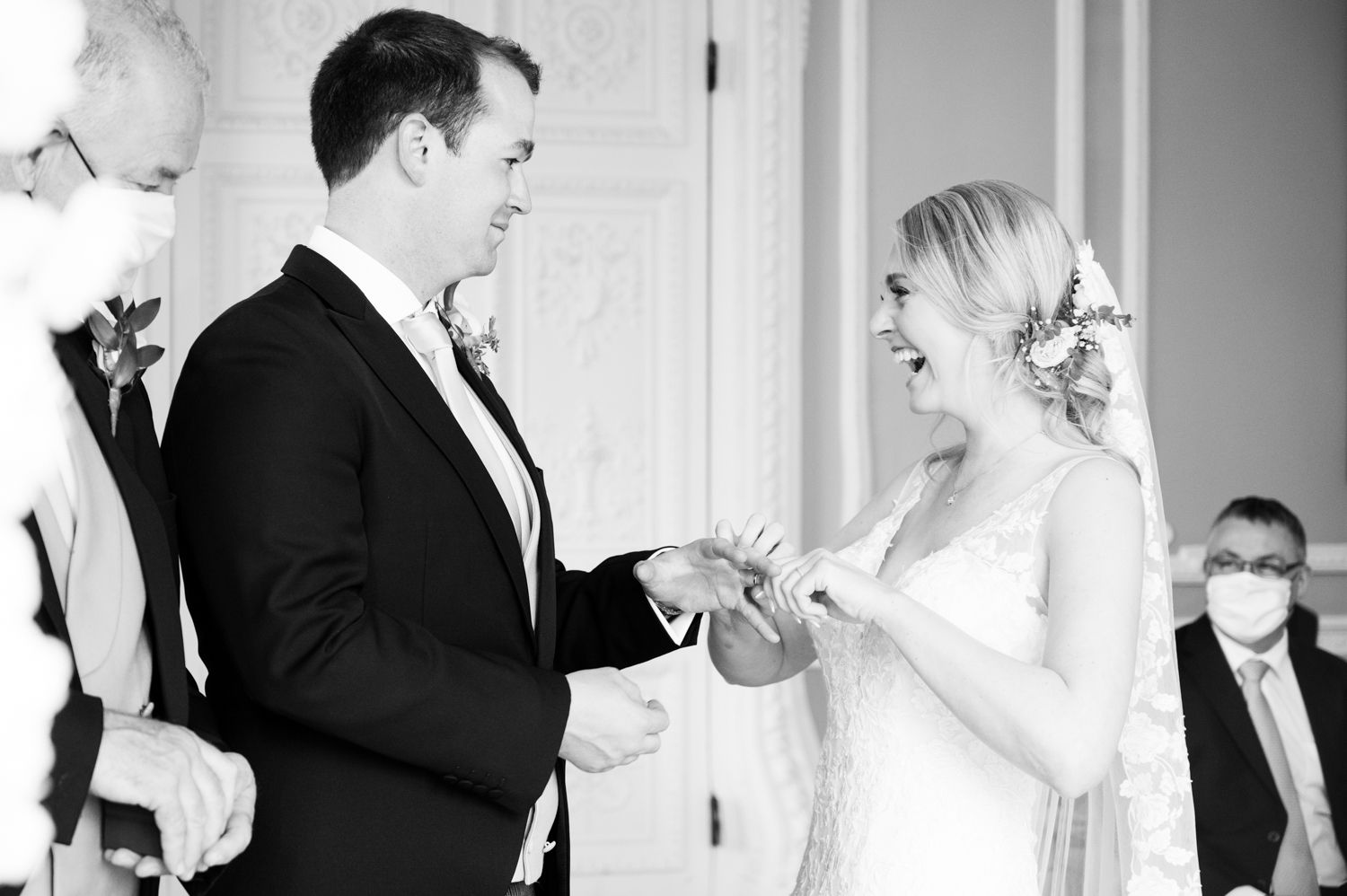 Black and white photo of wedding ceremony ring exchange moment.