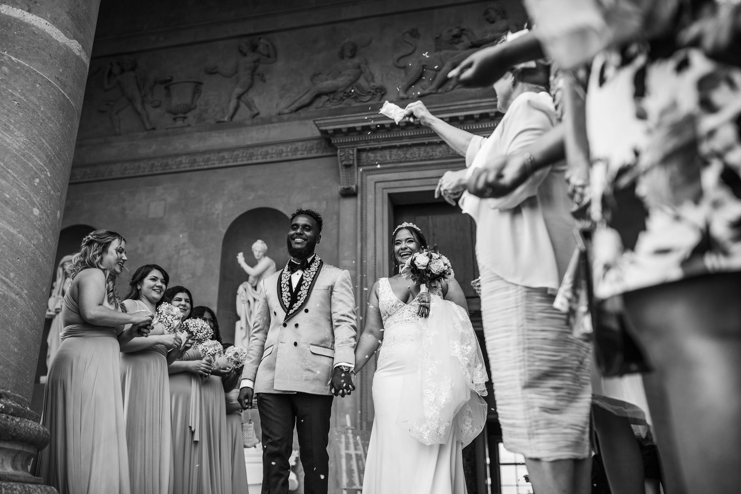 Black and white photo of wedding ceremony exit at grand historic venue.
