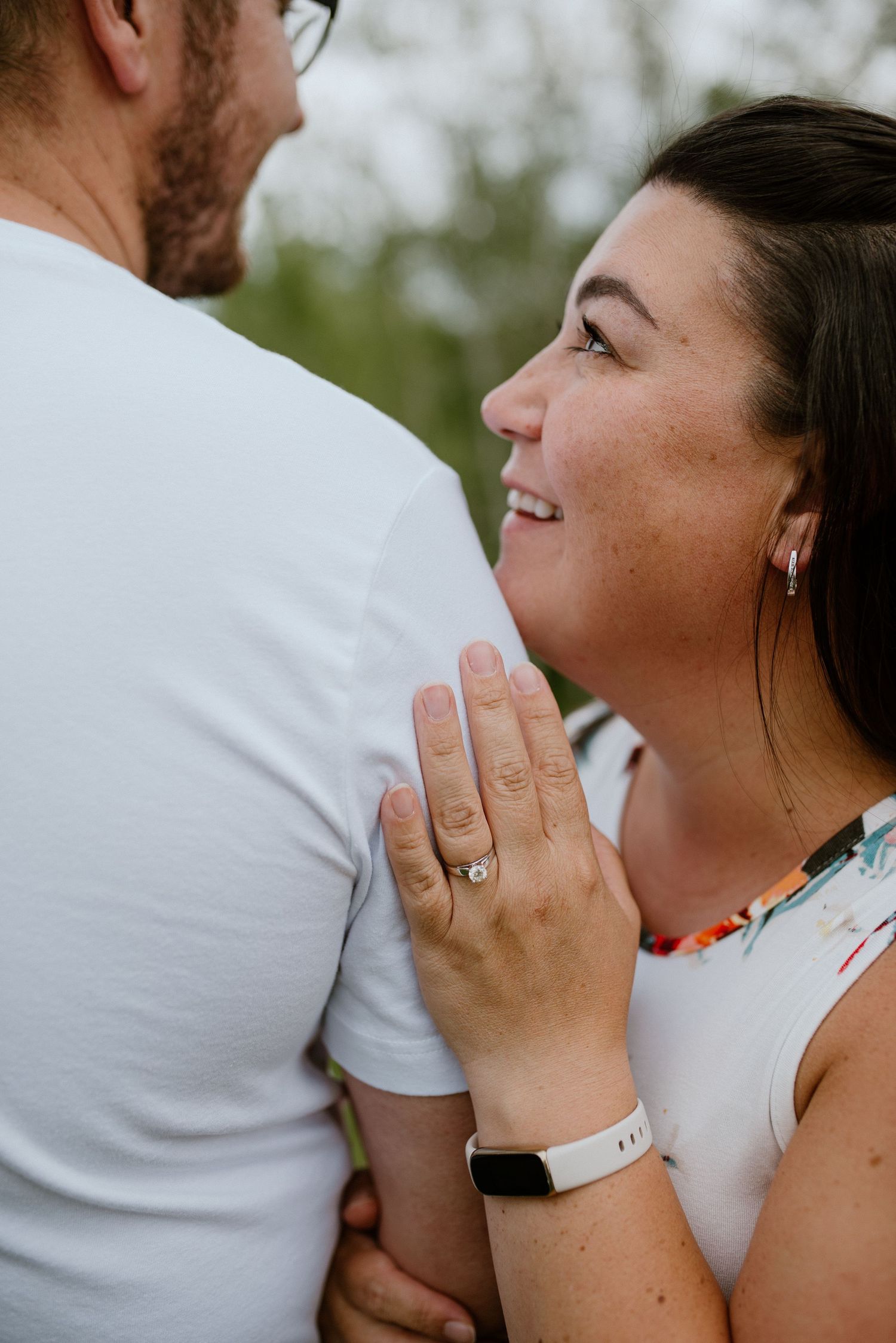Close-up view of engagement ring shown during outdoor couple portrait session.