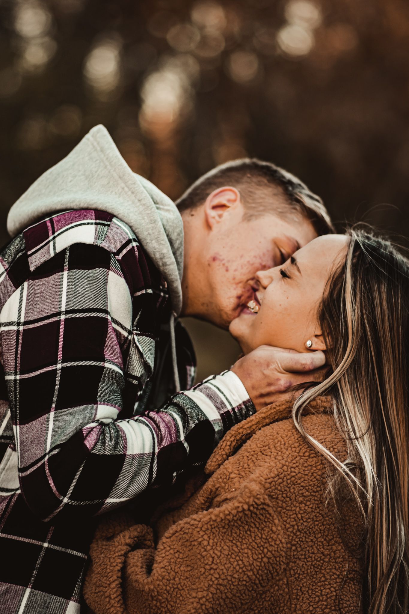 Intimate close-up of couple sharing tender moment in autumn wearing cozy fall layers.