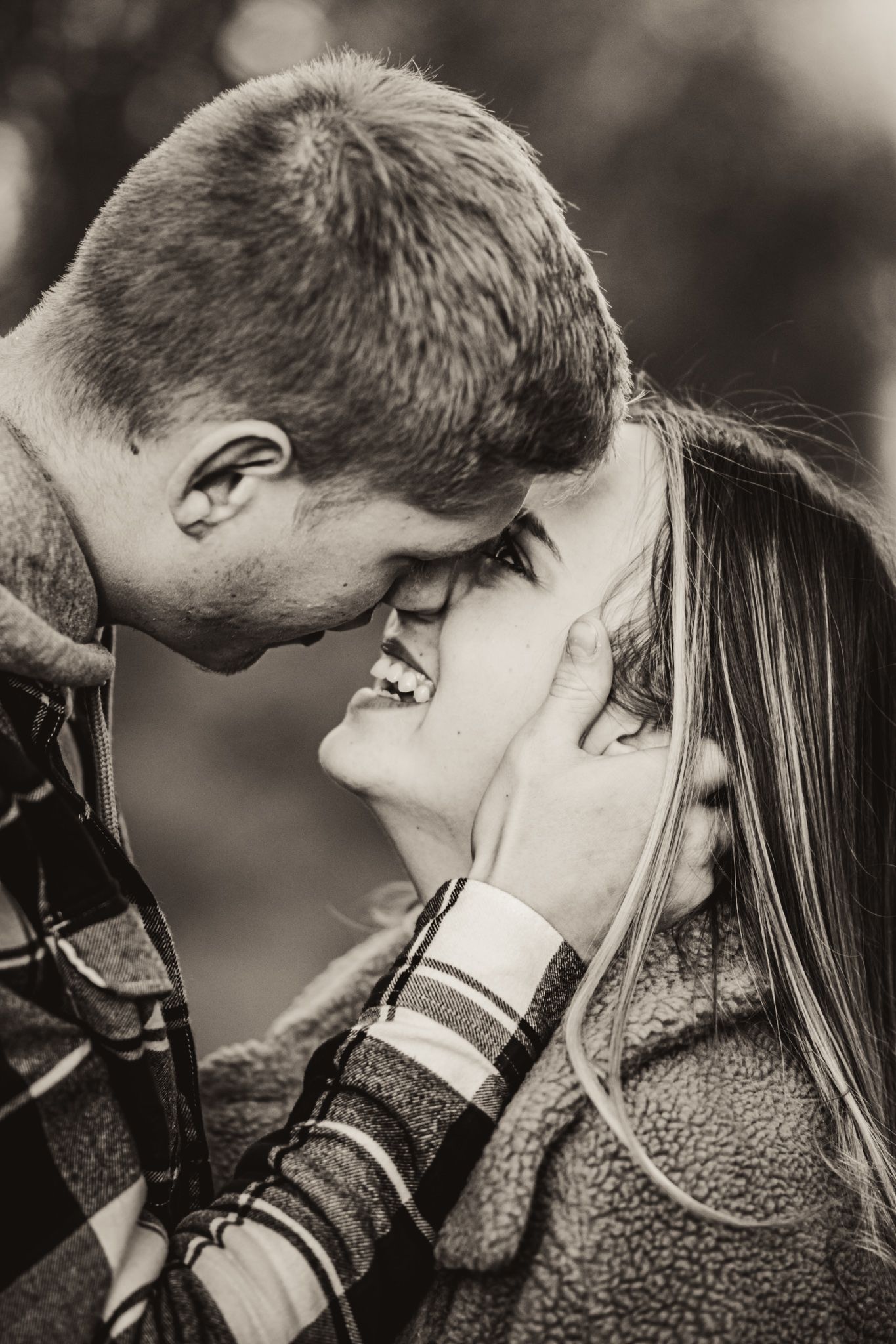 Black and white portrait of couple sharing intimate moment during fall photoshoot.